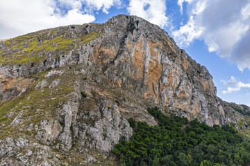 Aerial drone view of Caltavuturo, a historic Sicilian mountain town in Palermo, Italy, featuring its medieval castle, rugged surrounding cliffs, and scenic landscapes of the Madonie Mountains