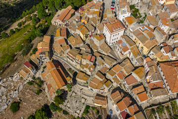Fototapeta premium Aerial drone view of Sclafani Bagni, a small historic Sicilian mountain town perched on cliffs with panoramic views of Caltavuturo and rugged Madonie Mountains, Sicily, Italy.Small Village in Sicily