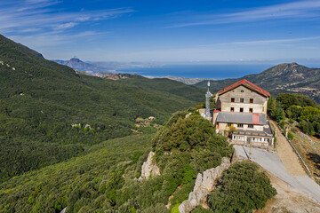 Fototapeta premium Aerial drone view of Piano Zucchi, a historic Sicilian mountain village at 1100 meters above sea level, surrounded by dense oak forests in the heart of Madonie Park, Isnello, Sicily, Italy
