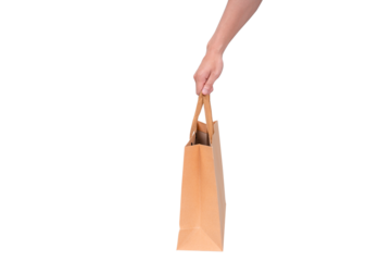 Hand holding a blank brown paper bag, isolated on a transparent background.