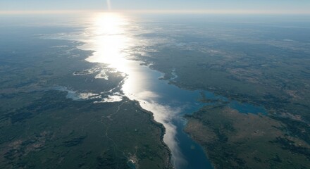 High-angle view of a waterway cutting through landscape. Sunlight highlights the water