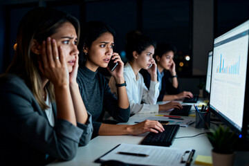 Women in the office looking at a computer, analyzing charts and monitoring trends.