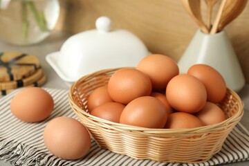Raw chicken eggs and kitchen utensils on countertop, closeup