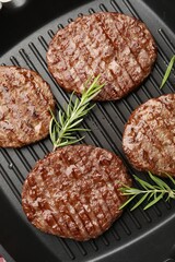 Pan with grilled patties and rosemary, top view