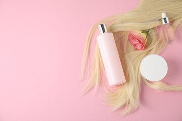 Lock of blonde hair, cosmetic products and flower on pink background, flat lay. Space for text