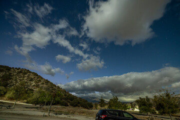 Twilight and blue hour settle over the canyon as the stars begin to emerge from behind the clouds in the sky