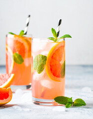 A glass of pink drink with a black and white straw in it