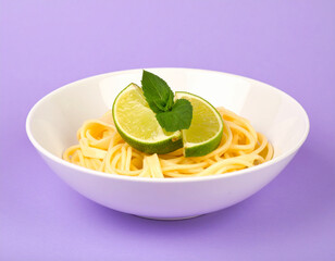 A plate of pasta with a green leaf on top