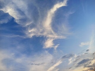 The beauty of the blue sky decorated with a unique spread of white clouds resembling flying birds and swirling winds in the afternoon...
