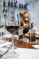  Red wine glass with blurred Sommelier woman tasting at wine store