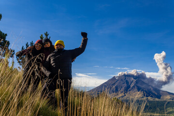 Friends hiking iztaccihuatl volcano with popocatepetl erupting in mexico