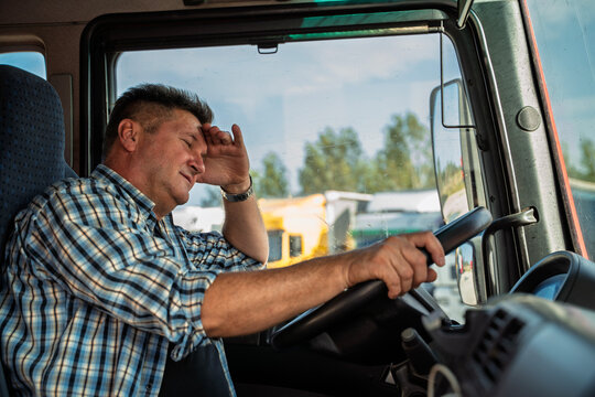 Truck driver tired of everything, or messed up something. Holding one hand on the forehead with disbelief on his face 