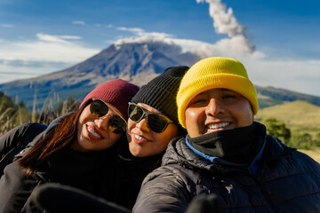 Friends taking selfie trekking iztaccihuatl volcano with popocatepetl erupting