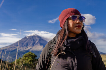 Hiker with backpack enjoying mountain view and clear blue sky