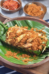 Grilled rice with shredded chicken and spiced grated coconut, wrapped in banana leaves, a traditional Indonesian dish