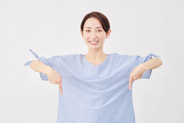 女性　ミドルエイジ　下を指差す　白背景