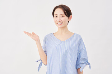 女性　ミドルエイジ　手のひらで左を指す　白背景