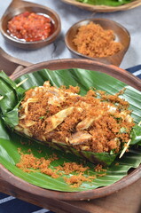 Grilled rice with shredded chicken and spiced grated coconut, wrapped in banana leaves, a traditional Indonesian dish
