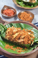 Grilled rice with shredded chicken and spiced grated coconut, wrapped in banana leaves, a traditional Indonesian dish