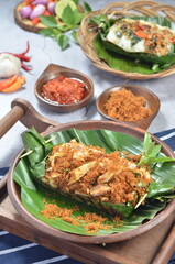 Grilled rice with shredded chicken and spiced grated coconut, wrapped in banana leaves, a traditional Indonesian dish