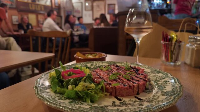 Enjoy a gourmet dinner with a fresh salad and fine wine at a cozy restaurant, ideal for relaxed moments with loved ones