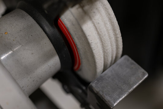 Ground grooves in a white disc on a bench grinder.