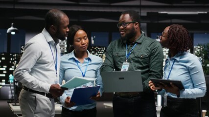 Black corporate staff working together on report writing in the office, collaborating on building a new development strategy. Reviewing insights to enhance efficiency and progress. Camera B.