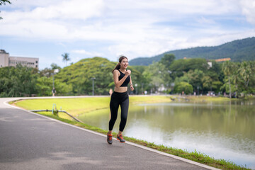 Woman jogging in park next to lake during day