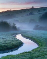 Fototapeta premium Serene Misty Morning Landscape with Winding River, Frosty Grass, Rolling Hills, and Pastel Sunrise Sky
