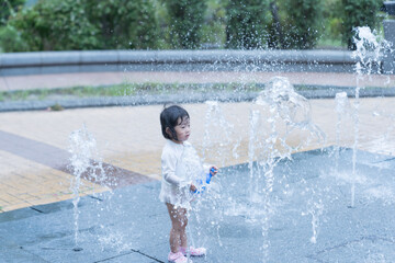マンション広場の噴水で遊ぶ日本人の幼児