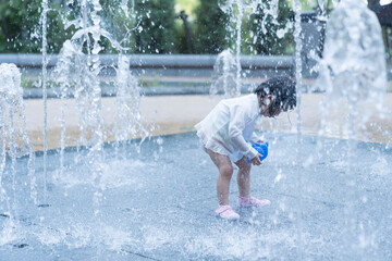 マンション広場の噴水で遊ぶ日本人の幼児