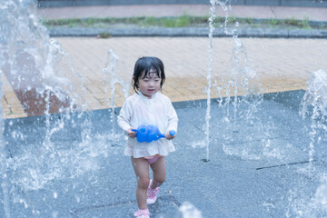 マンション広場の噴水で遊ぶ日本人の幼児
