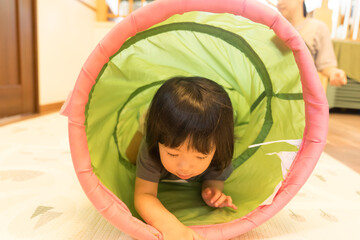 トンネルの遊具で遊ぶ女の子の幼児