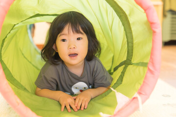 トンネルの遊具で遊ぶ女の子の幼児