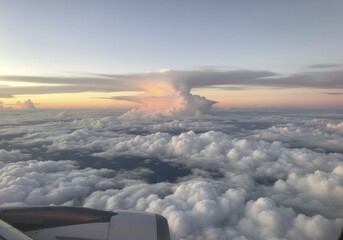 Obraz premium Breathtaking Aerial View of a Dramatic Cumulonimbus Anvil Cloud at Golden Hour from an Airplane Window