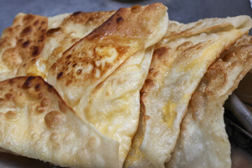 Delicious and appetizing close up of golden brown Roti Canai. savory Asian flatbread popular for breakfast in Malaysia, showing crispy texture and flaky layers