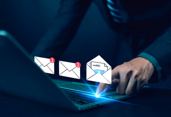 Businessman using laptop with glowing email icons and notification alerts, representing digital communication, email marketing, online messaging, connection, and modern business technology concept.