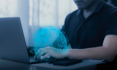 Person working on laptop with digital globe animation in a bright indoor setting during daytime. Global connection concept.