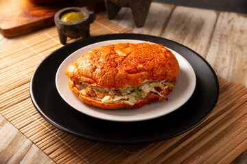 Pambazo. Sandwich marinated in sauce and roasted on a comal traditionally stuffed with potatoes and chorizo, a classic of Mexican street food.