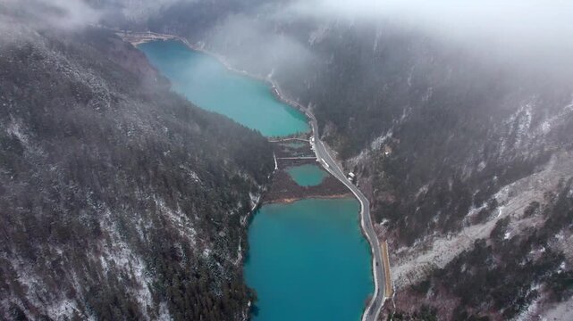 Drone view of Jiuzhaigou National Park in spring in Sichuan Province China. It features cascading waterfalls, turquoise blue lakes, and stunning mountain valleys. 4K real time footage travel concept.