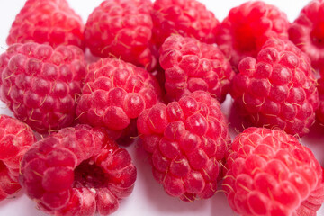 juicy raspberries are piled together in neat cluster, their rich red hue and delicate texture. perfect for snacking or adding to dishes. close up.