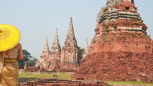 Thailand, Ayutthaya - march 15th, 2023: Woman in traditional Thai dress pose sightseeing visit ancient Buddha statue.Ayutthaya historical park. UNESCO World Heritage Site