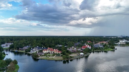 Obraz premium Aerial view of luxury houses in Houston, Woodlands by the lake with dramatic cloudy sky in Texas, United States on 10/08/2025