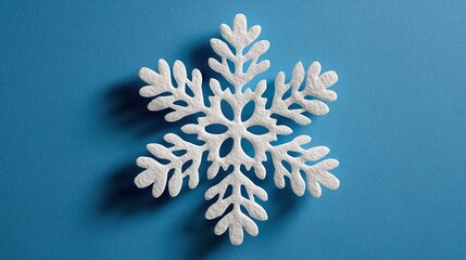 Minimal Snowflake on Bright Blue Background. Flat Lay Season Concept.