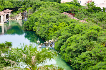 爽やかな南国の鮮やかなヤシが映える高級リゾートホテルのラグーン・中庭・池と滝（沖縄県宮古島市）
