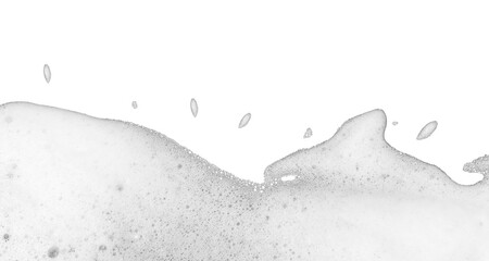 High-key abstract photograph of layer of white foam or suds spreading across bottom portion of transparent background. Foam composed numerous tiny delicate bubbles textured slightly frothy appearance