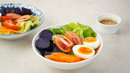 Healthy Salad Bowl, mix vegetables carrots, lettuce, tomatoes, sweet potatoes, and egg with sesame sauce.