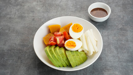 Healthy Salad Bowl, mix vegetables jicama, avocado, pumpkin, tomatoes and egg with sesame sauce.