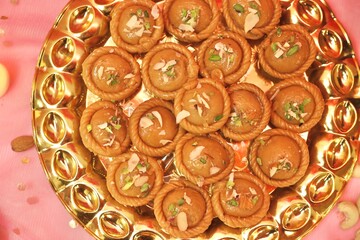 Chandrakala beautifully decorated in a golden plate with festive celebration background