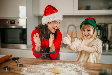 Mother and daughter baking christmas cookies sharing joy